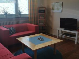 KronshagenGemütliche Gästewohnung in ruhiger Lage的客厅配有红色沙发和茶几