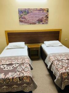 安曼亚洲大酒店的两张位于酒店客房的床,墙上挂着照片