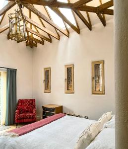 邓弗里斯The Stables - Luxury Cottage的一间卧室配有一张床和一张红色椅子