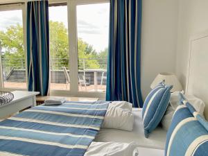 蒂门多弗施特兰德Appartement-Hotel Timmendorfer Strand的一间卧室设有一张床和一个大窗户