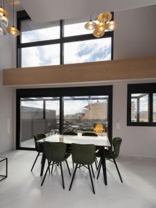 雅典LUX&EASY Athens Downtown Residences的一间设有白色桌子和绿色椅子的用餐室