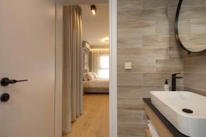 雅典LUX&EASY Athens Downtown Residences的浴室设有白色水槽和镜子