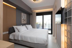 雅典LUX&EASY Athens Downtown Residences的卧室设有白色的床和大窗户