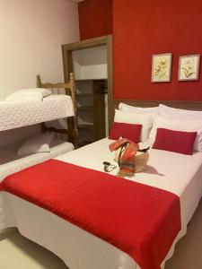 托雷斯Pousada Natália的一间卧室设有两张床和红色的墙壁