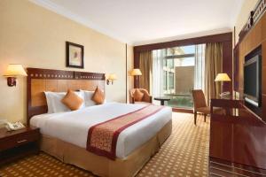 利雅德Ramada by Wyndham Hotel Riyadh的酒店客房设有一张大床和一台电视。