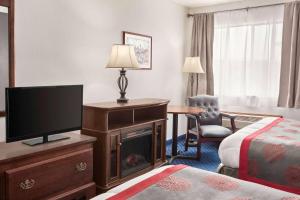 阿克塔华美达阿克塔酒店的酒店客房设有电视和床。
