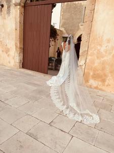 诺托Relais Terre di Romanello的身着婚纱的女友,靠在建筑物上