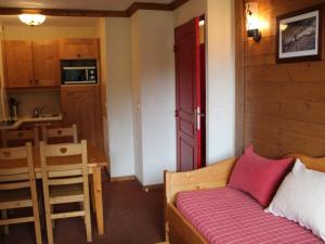 琴山朗勒堡Appartement Lanslebourg-Mont-Cenis, 3 pièces, 6 personnes - FR-1-508-234的一间卧室配有一张红色门的床和一间厨房