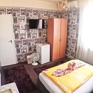 尼赖吉哈佐Jocó Panzió的一间卧室配有一张床,墙上贴有壁纸