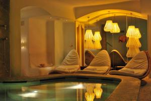 热那亚萨沃亚大酒店的一个带椅子的房间和一个灯光游泳池