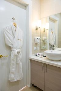奇姆肯特Hotel FN Shymkent的浴室设有挂在水槽旁的白色长袍