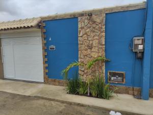 卡波布里奥Doce Lar的两扇蓝色车库门,位于一栋带石墙的建筑内