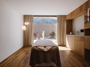 纳图尔诺Lindenhof Pure Luxury & Spa DolceVita Resort的一间卧室配有一张床,厨房配有窗户