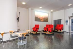 斯图加特斯图加特国际青年旅舍的一间设有红色椅子和桌子的等候室