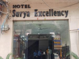 贾姆穆Hotel Surya Excellency By WB Inn的大楼上酒店导航标志前的商店