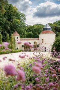 ReugnyRelais & Château Louise de La Vallière的一座花园,在一座建筑前方种有粉红色花卉