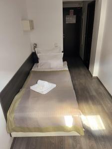 克拉古耶瓦茨Garni hotel King的一张大床,位于带床垫罩的房间