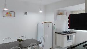 因巴塞Casa em Imbassai的厨房配有白色冰箱和桌子