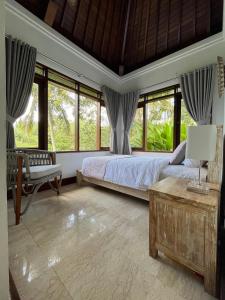 BalianBalian Bliss Retreat Bungalow & Villas的一间卧室设有一张床和一些窗户。