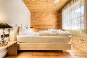 布兰德Uralp Royal by A-Appartments的一间卧室设有一张床和木墙