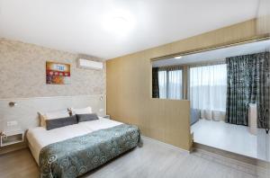 普罗夫迪夫Hotel Capri的酒店客房设有床和窗户。