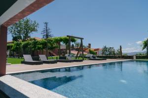 比索达雷加Quinta dos Românticos - Charm House & Wine SPA的一座带躺椅的游泳池位于大楼旁