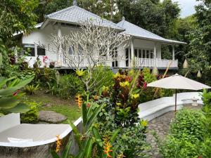 BalianBalian Bliss Retreat Bungalow & Villas的一座带花园和遮阳伞的房子