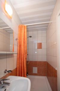 塔林Revalia Airport-Bus Station One-Bedroom Apartment的浴室设有橙色淋浴帘和水槽