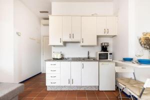 埃尔罗西奥GINVA - Apartahotel El Rocio-Doñana的厨房配有白色橱柜和微波炉