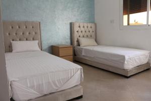 纳祖尔Panorama Apartment Nador Jadid Klima free Parking & Wifi的一间卧室设有两张床和床头柜