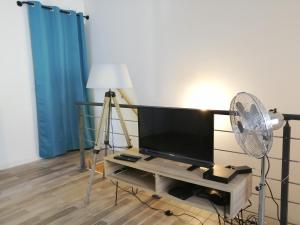 布隆Blue Rent的客厅配有风扇和平面电视。