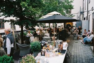 斯德哥尔摩NOFO Hotel, WorldHotels Crafted的一群坐在桌子上的人,拿着雨伞