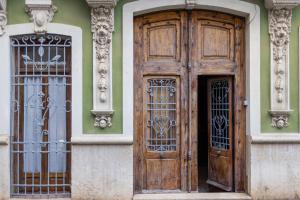 瓦伦西亚FLORIT FLATS - Traditional House in El Cabanyal的大楼一侧的两扇木门