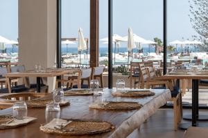 罗德岛卡利地亚Helea Lifestyle Beach Resort的用餐室设有桌椅和窗户。