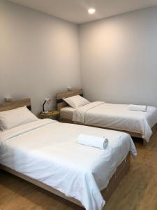 曼谷Tang Guang Aeum Coffee Residence的一间卧室配有两张带白色床单的床