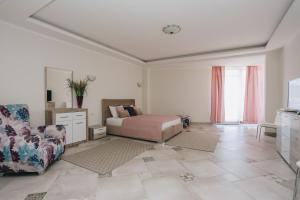 蒂瓦特Villa Semiramis的一间卧室配有一张床、一张沙发和一把椅子