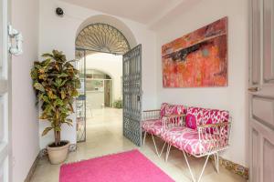 塞维利亚Santacruz Hostal Plaza的客厅配有粉红色的沙发和粉红色的地毯。