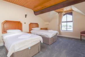 伊林港Falcon's Nest Hotel的一间卧室设有两张床和窗户。