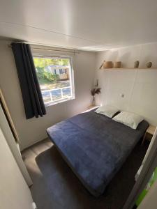 欧雷扬MOBIL HOME Climatisé G058的一间带一张大床的卧室,位于带窗户的房间内