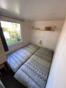欧雷扬MOBIL HOME Climatisé G058的一个小房间的一个床位,设有窗户
