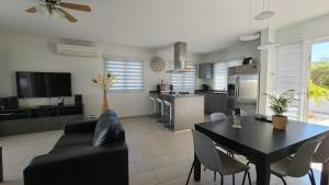 棕榈滩Beautiful luxury villa with private pool的一间带黑色桌子的客厅和一间厨房
