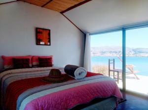 普诺Titicaca wasy lodge的一间卧室设有一张床,享有海景