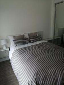埃斯特角城Apto en Punta del Este con Piscina Climatizada!!的一间卧室配有一张带条纹床单的大床