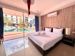 芭东海滩Baankasemsuk Resort 般咔 深宿的一间卧室设有一张床和一个大窗户