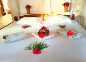 迪亚尼海滩迪亚尼海滩非洲梦别墅酒店的床上的一组毛巾和鲜花