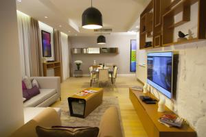 伊斯坦布尔狮子座公寓的带电视的客厅和带桌子的客厅。