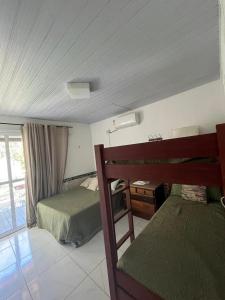 马拉戈日MARAGOGI FLAT BEIRA MAR的一间卧室设有两张床、一张桌子和一个窗口。
