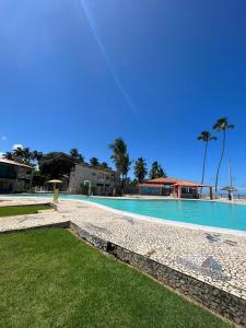 马拉戈日MARAGOGI FLAT BEIRA MAR的一座拥有蓝色海水和棕榈树的大型游泳池