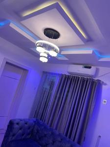 拉各斯GS HOMES的一间设有紫色灯和床的天花板客房