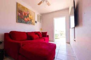 伊莎贝拉Playa y Campo Getaway Apartment, with Hot Tub的客厅里一张红色的沙发,墙上挂着一幅画